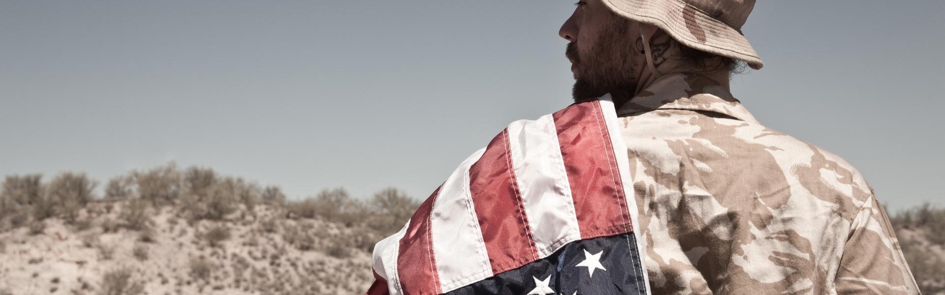 Contact Us page header image. Photo of a man in military uniform with an American Flag draped over his shoulder.